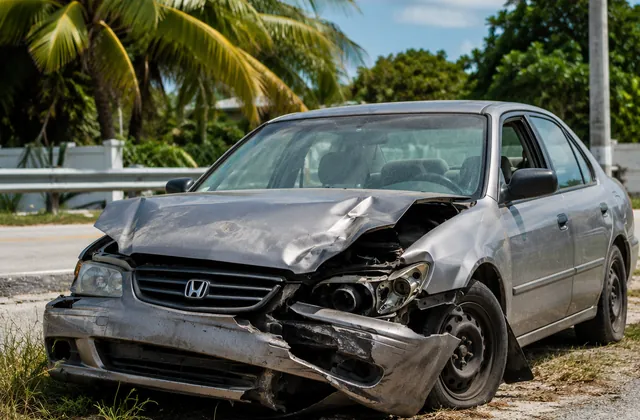 Accident-damaged car beside a tropical Florida road